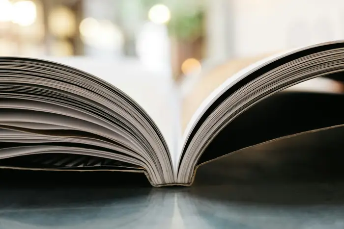 A large open book on a glossy surface